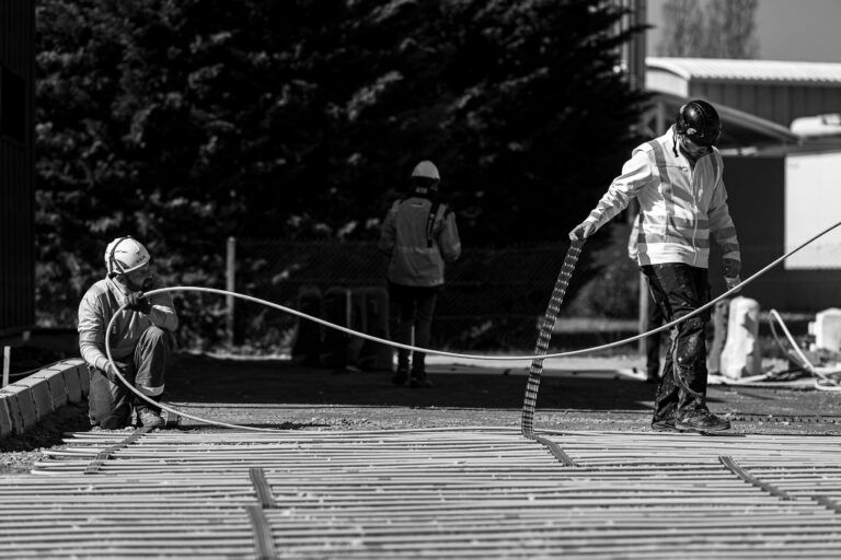 Des hommes sur un chantier installent un système de chauffage au sol